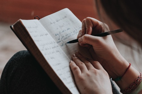 A female who is recovering from an eating disorder writing in her journal.