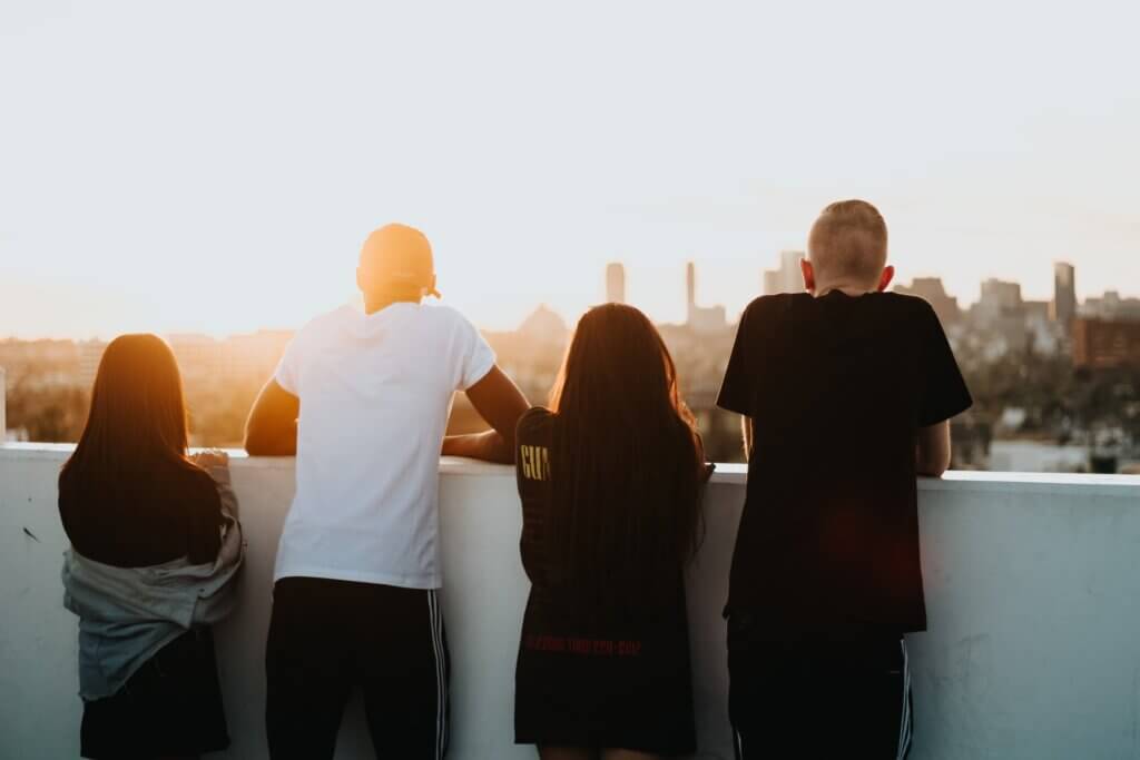 a group of teenagers look at a sunset