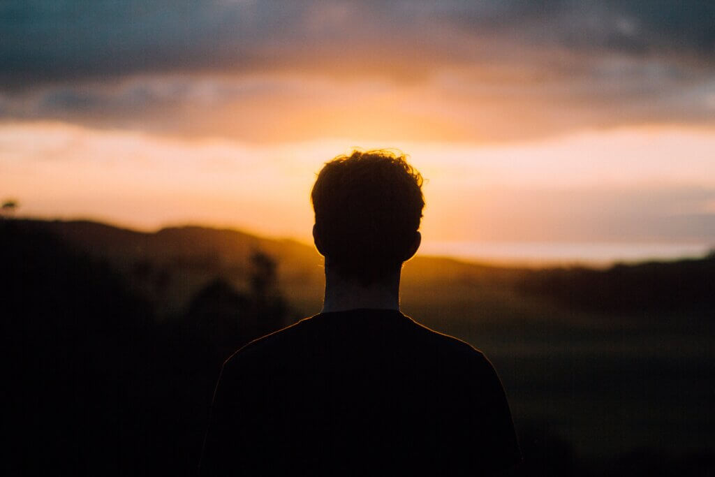 Individual facing the sunset