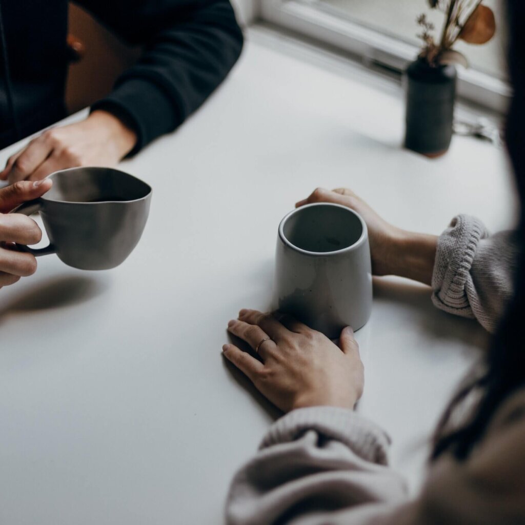2 persons at a table with tea cups