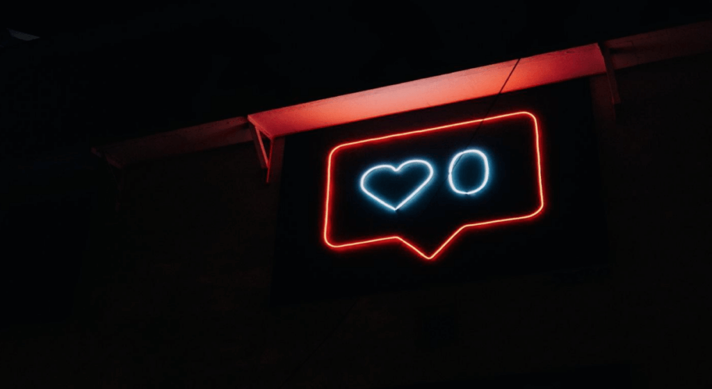 Neon light with Instagram "like symbol" which is a speak bubble with a heart and a 0 inside