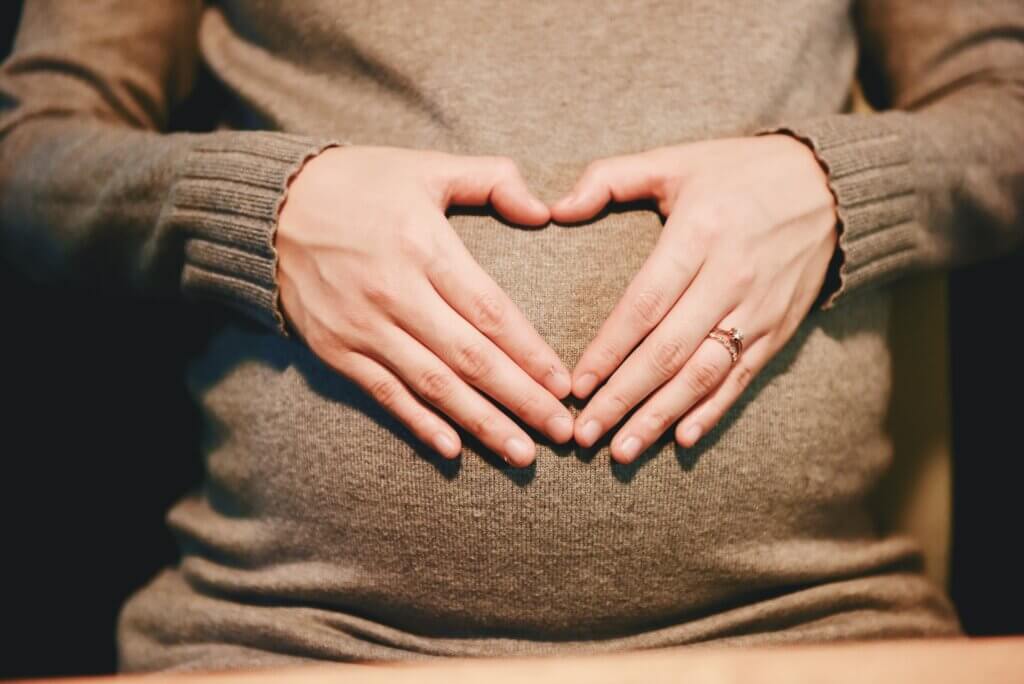 Image of individual holding their pregnant stomach