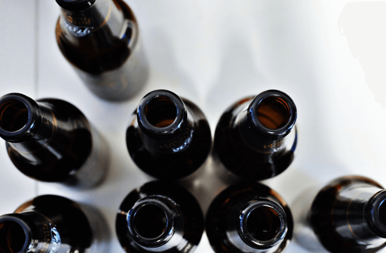 Image of tops of beer bottles against a white background taken from above