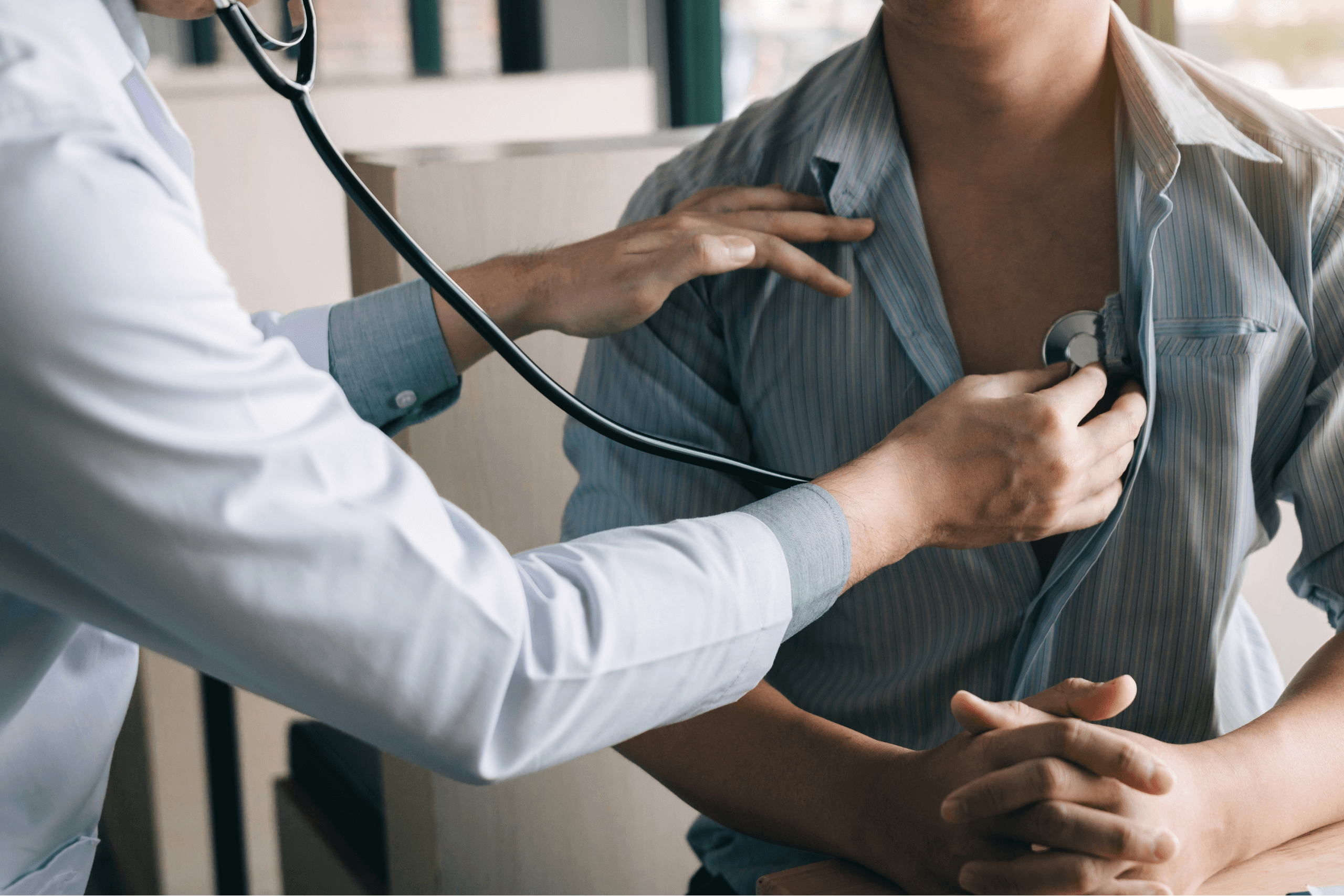 Doctor using a stethoscope to listen to a patient's heartbeat.