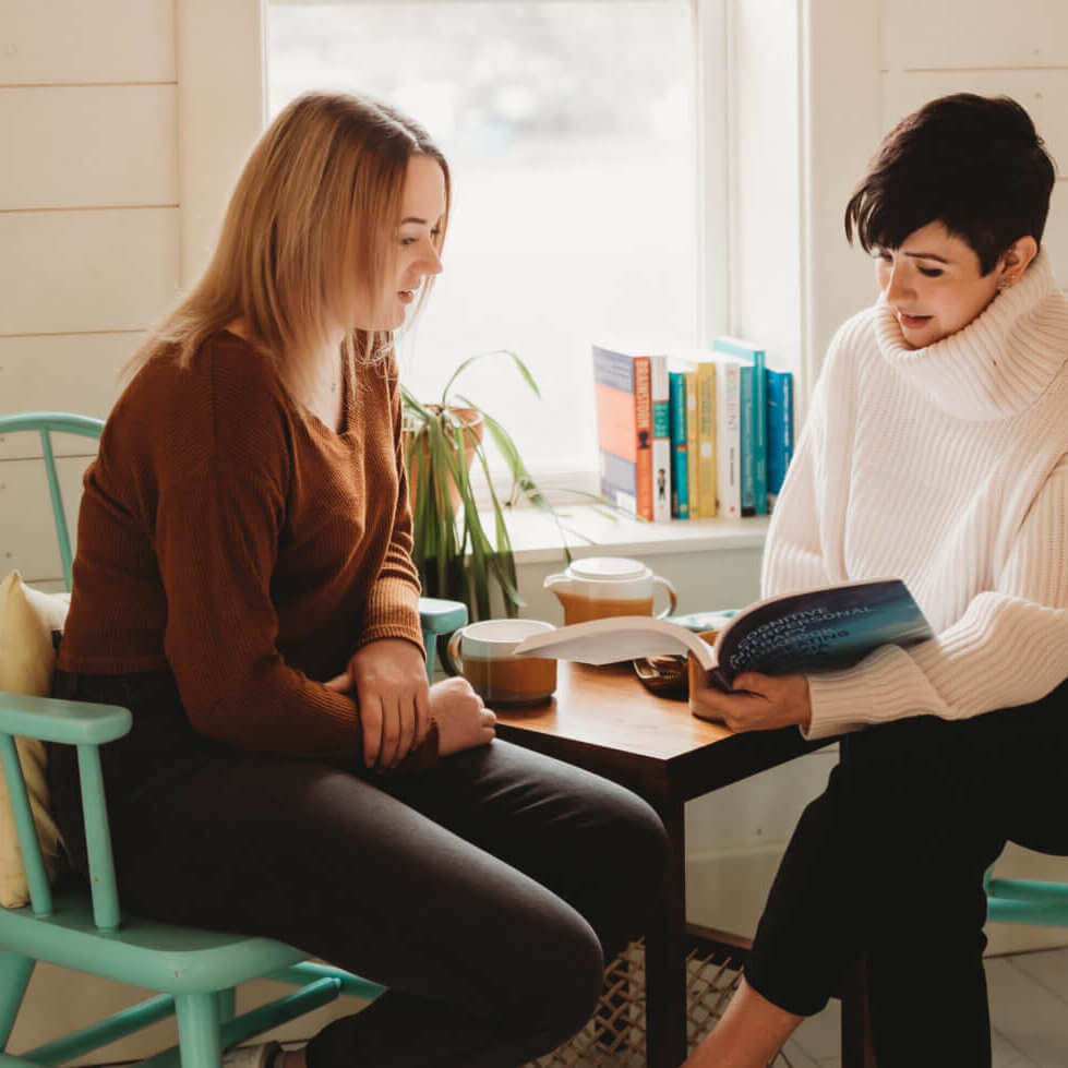 An individual sitting next to someone and teaching them.
