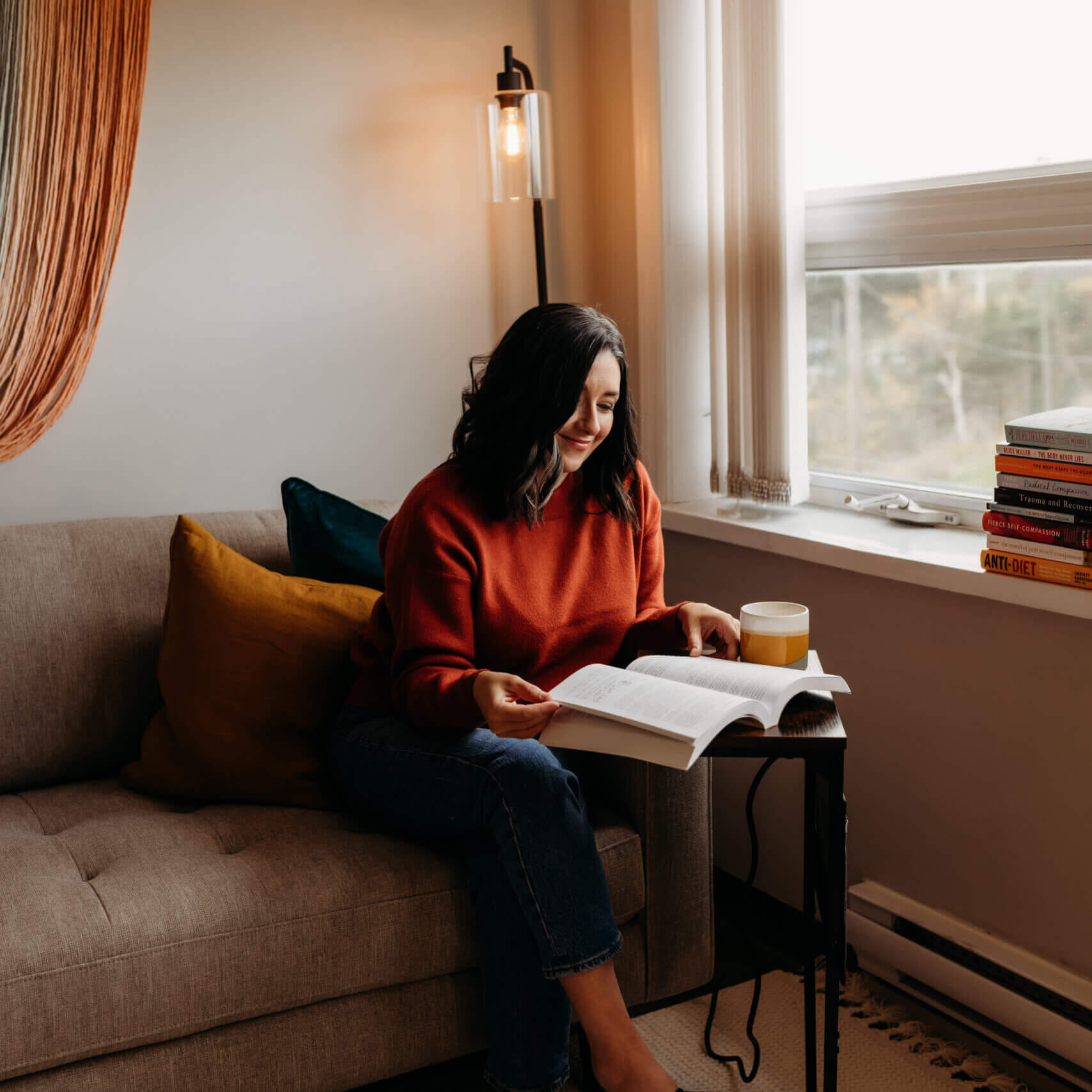 Jillian sitting at a desk reading a book.